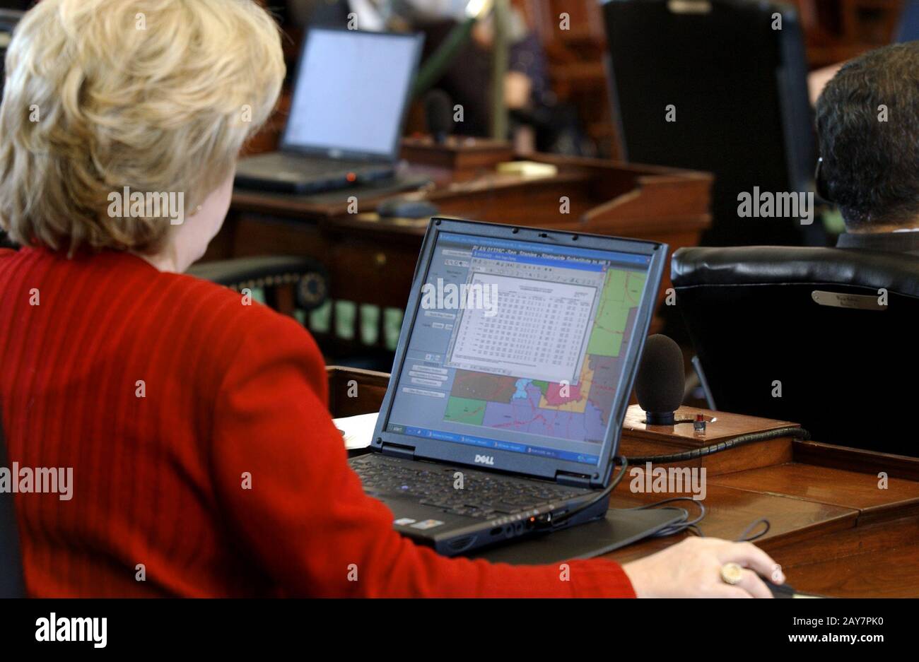 Austin, Texas July 21, 2003:  During special session of the Texas Legislature to consider a redistricting bill intended to give more of a Republican majority to U.S. Congress,  Sen. Jane Nelson reads her redistricting map on her laptop computer at her desk on the Senate floor. ©Bob Daemmrich Stock Photo