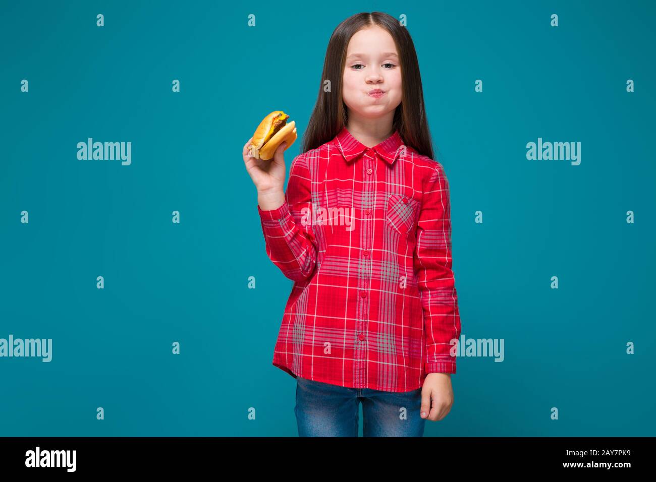 Cute little girl in checkered shirt with brunet hair hold burger Stock Photo