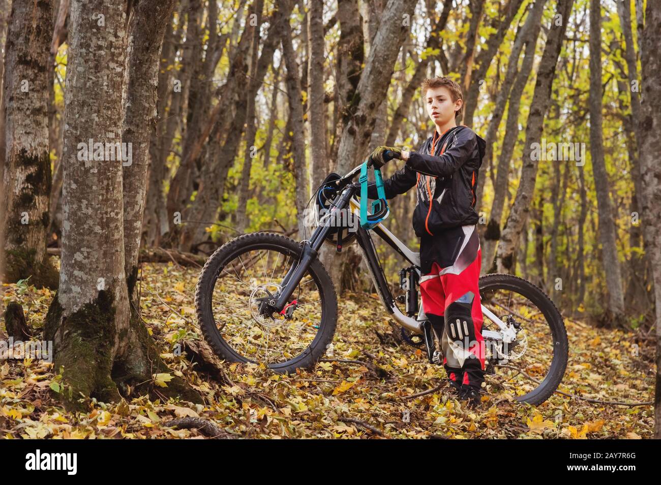 Portrait of a young rider in full protection of a full face helmet mask and gloves on a bicycle Stock Photo