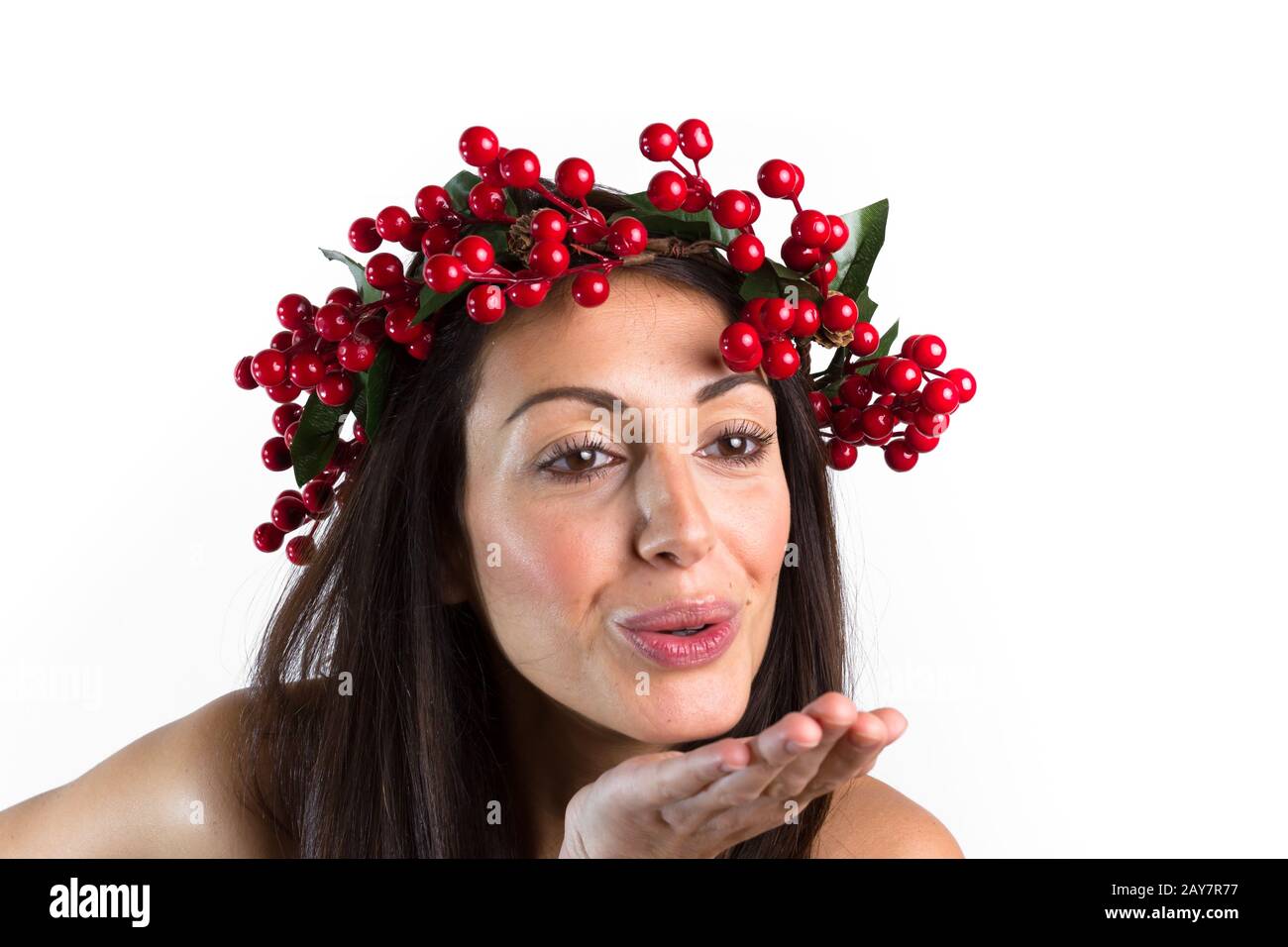 Smiling woman, with a Christmas wreath on her head, send a kiss. Stock Photo