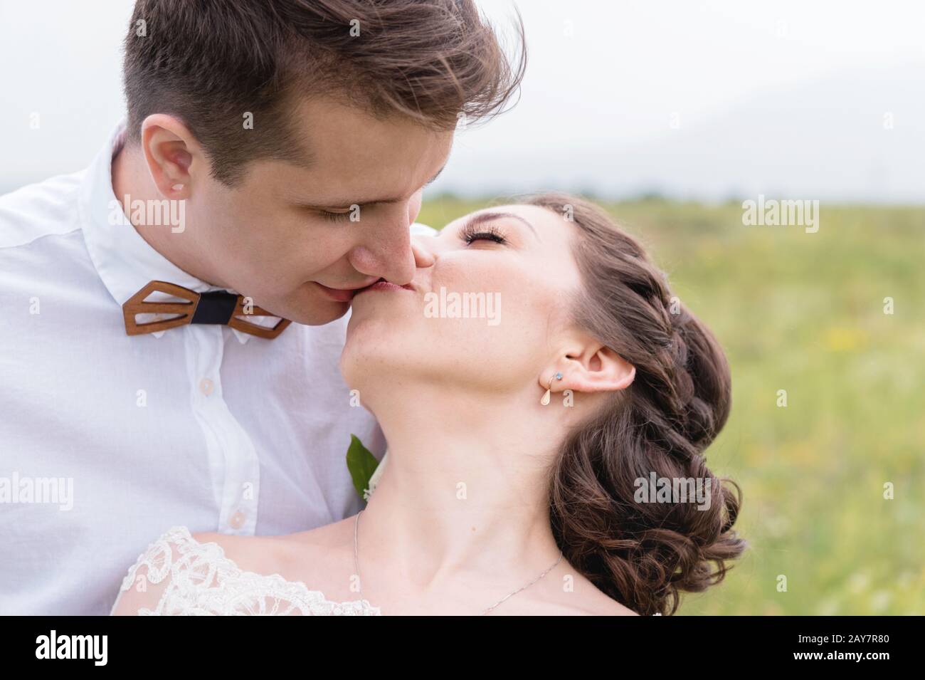 a couple of newlyweds standing in an arms embrace in nature Stock Photo