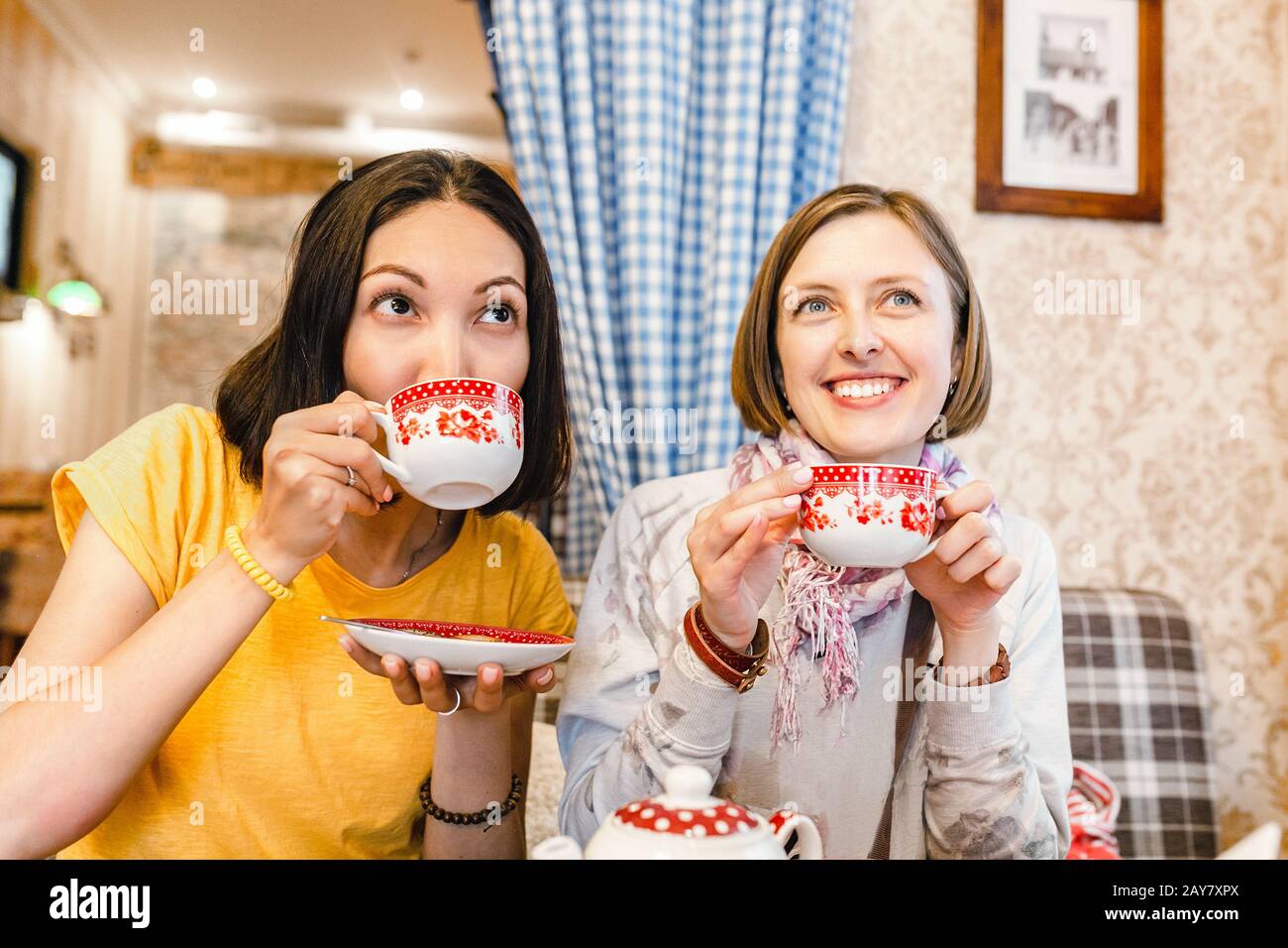 Friends talking and laughing while having cup of tea in cafe Stock ...