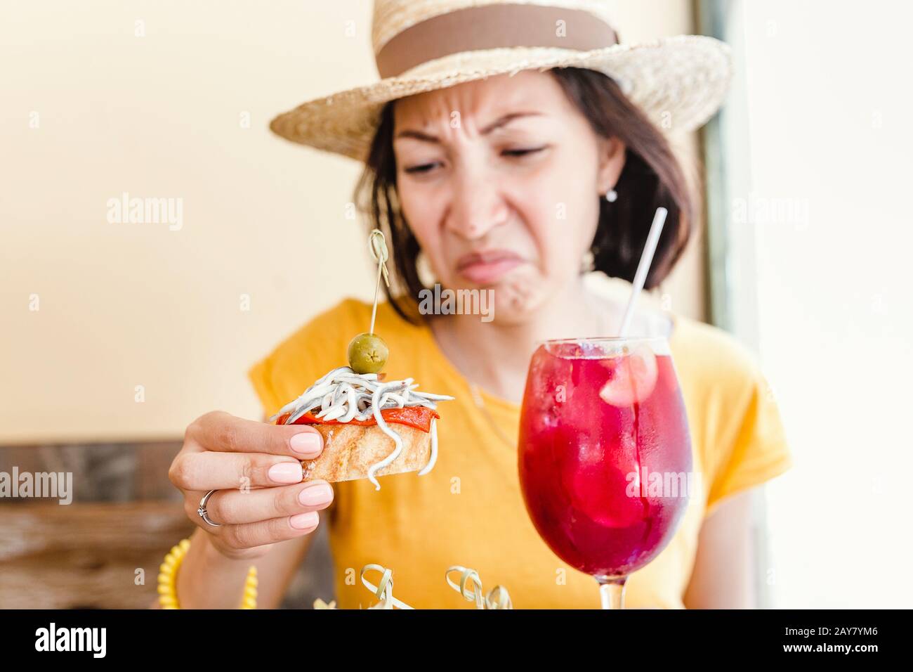 A Woman Tries Spanish Cuisine For The First Time And She Is Unhappy With The Disgusting Taste Of Delicacy Stock Photo Alamy