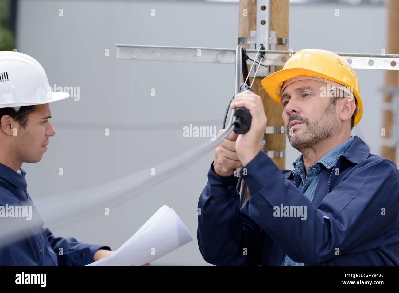 electrical line apprentice observing the teachers demonstration Stock Photo
