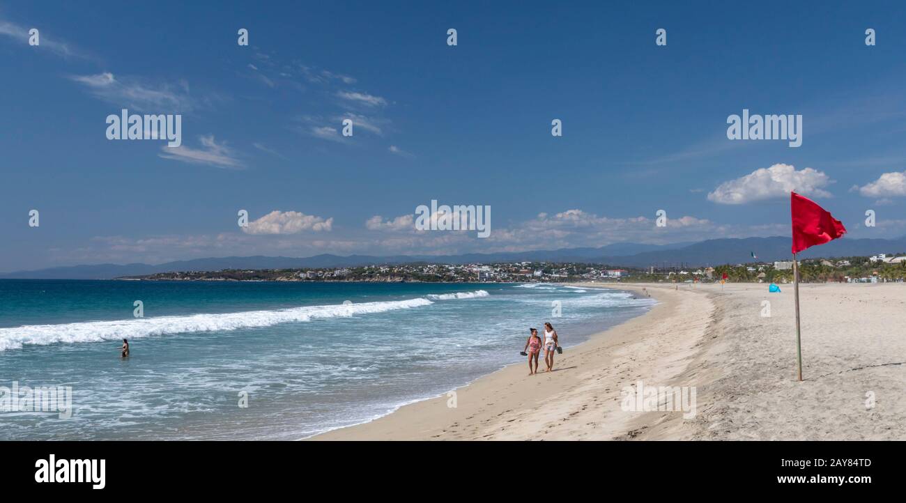 Brisas de Zicatela, Oaxaca, Mexico - The Pacific Ocean beach, looking towards Puerto Escondido. The red flag warns of dangerous swimming conditions. Stock Photo