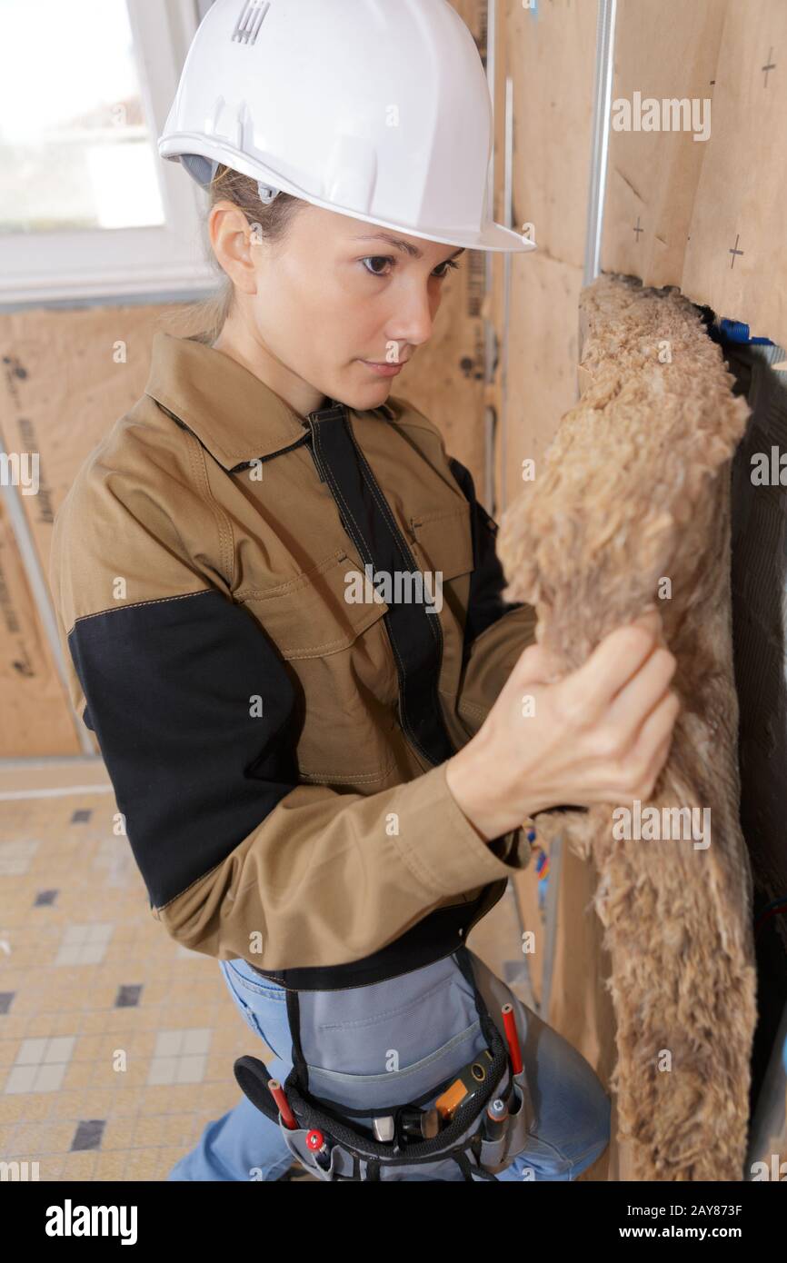 female worker at a indoors wall insulation works Stock Photo - Alamy