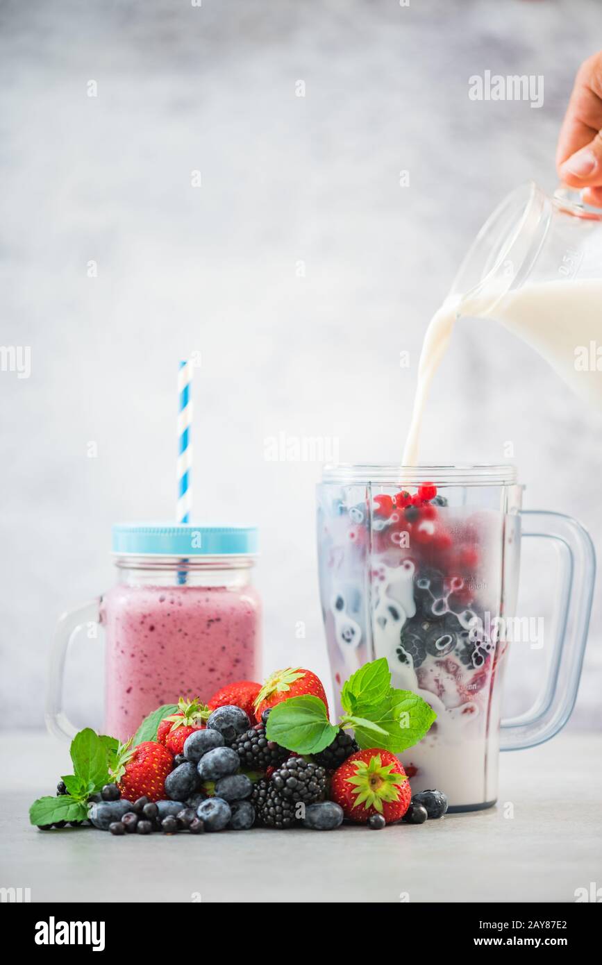 Pouring milk into blender, smoothie making Stock Photo Alamy