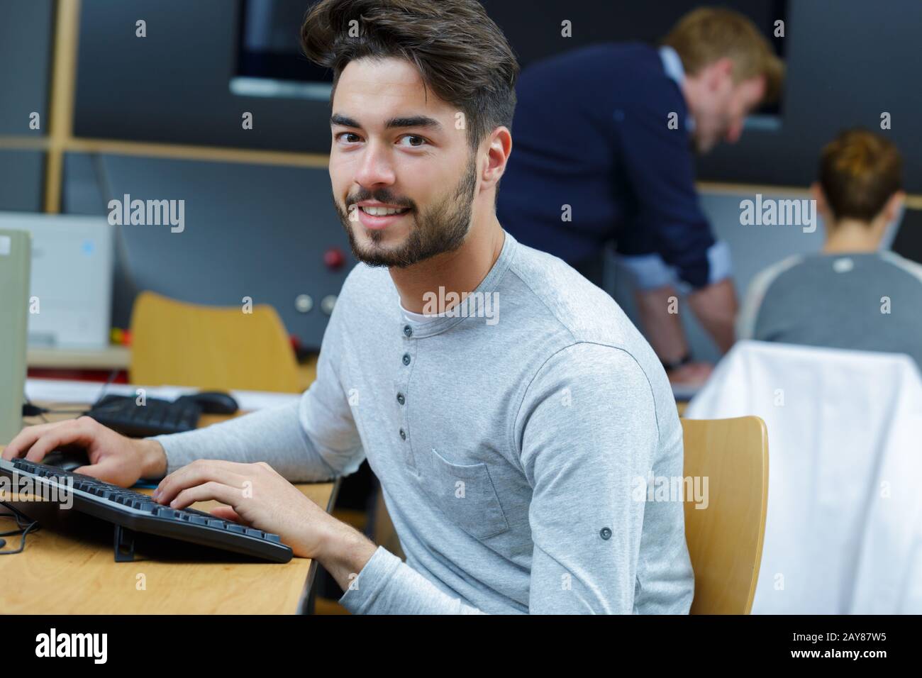 portrait of young male student using computer Stock Photo