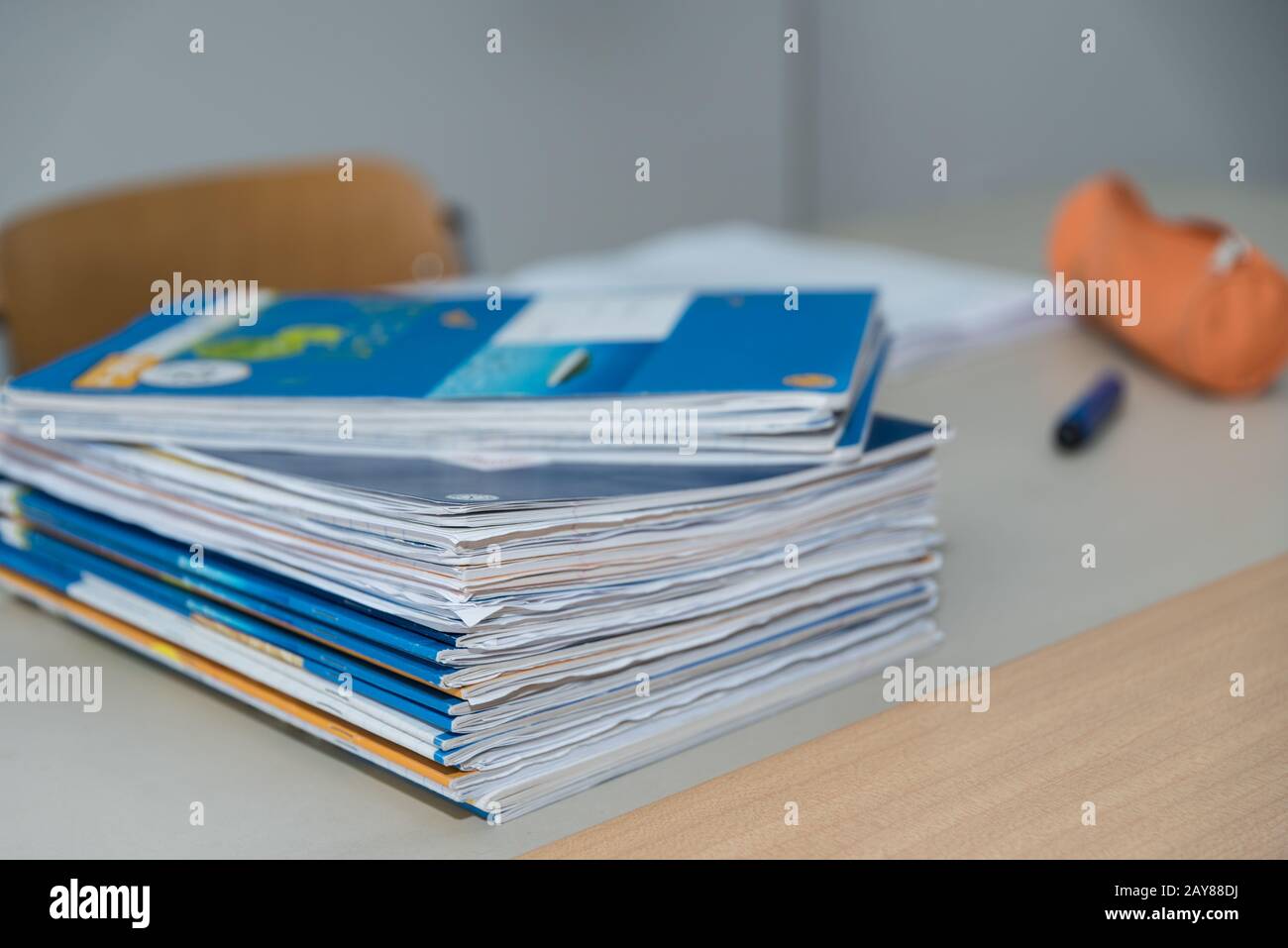 Stack of student notebooks on a teacher's desk in the classroom Stock Photo