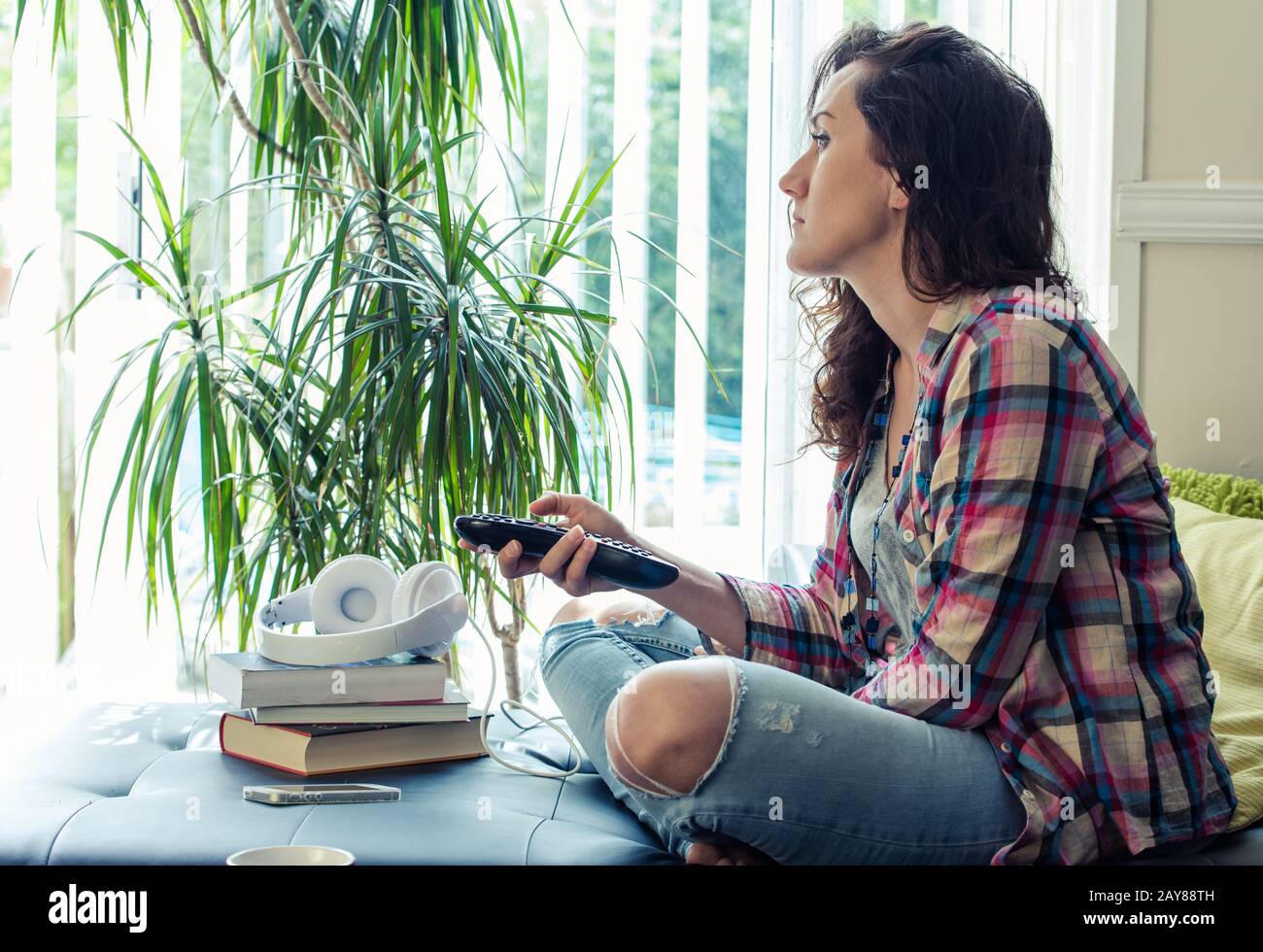 young woman relaxing watching TV on sofa Stock Photo Alamy