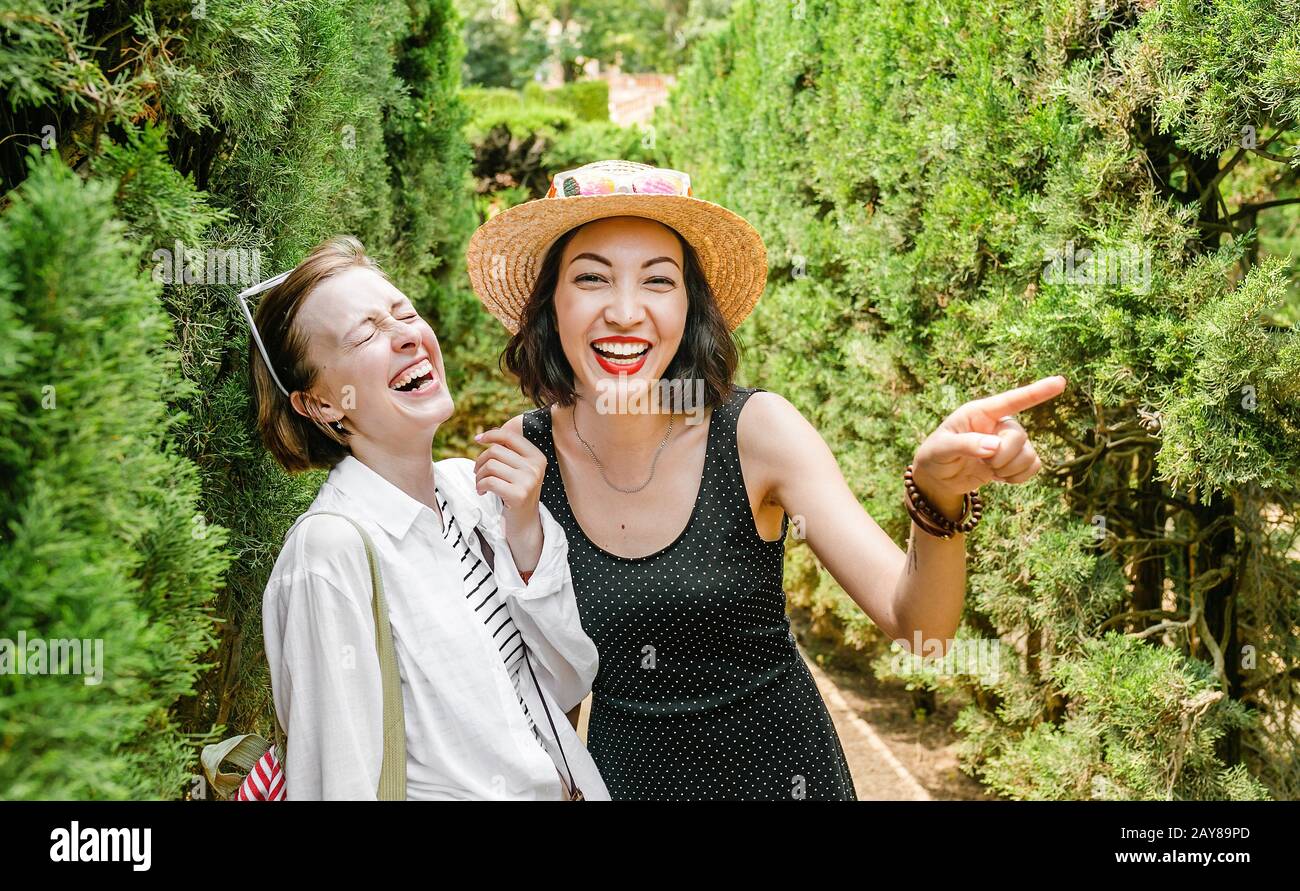 Two women friends laughing and hugging outdoors at labyrinth Stock Photo