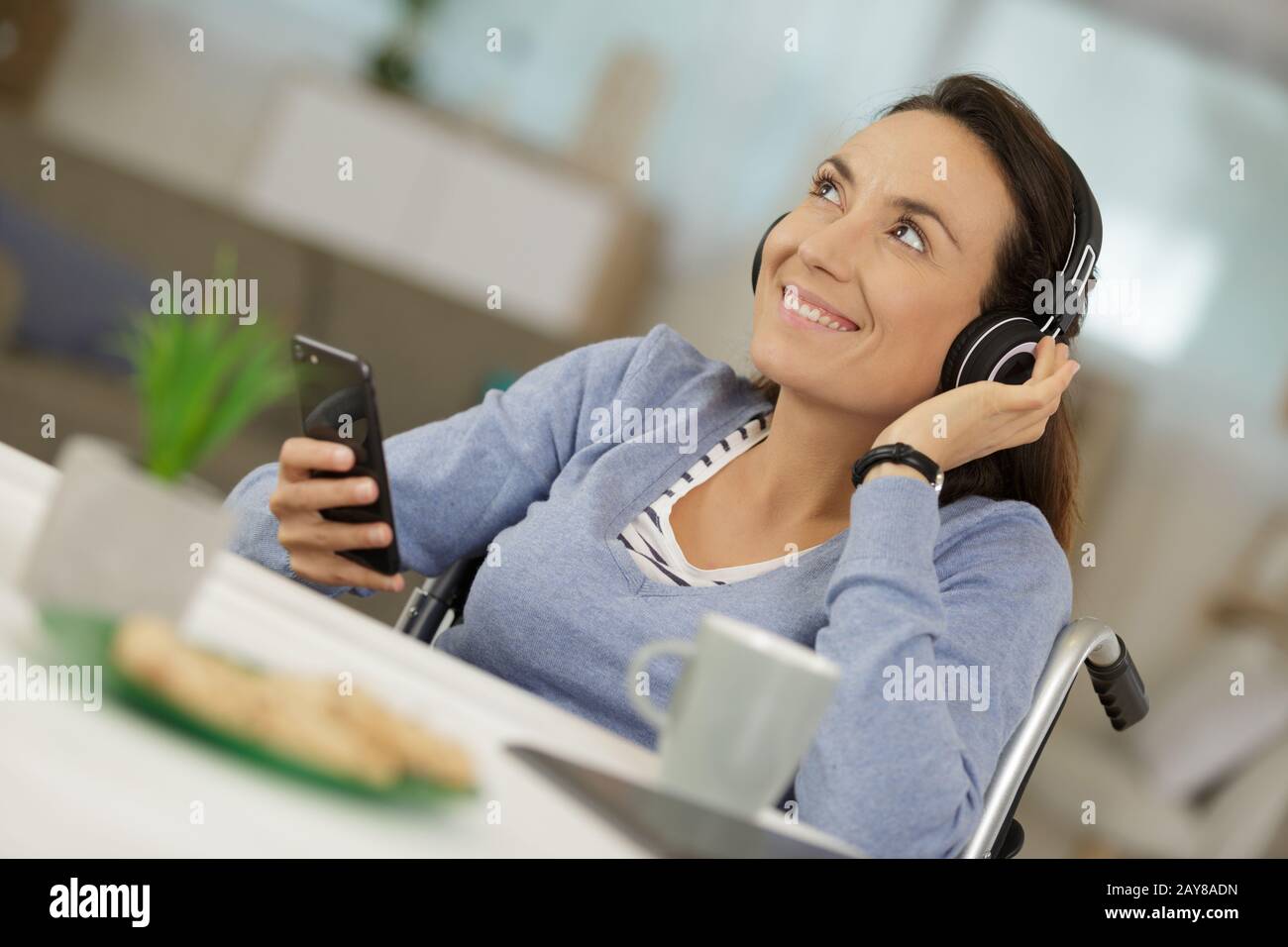happy disabled woman smiling while holding her phone Stock Photo - Alamy