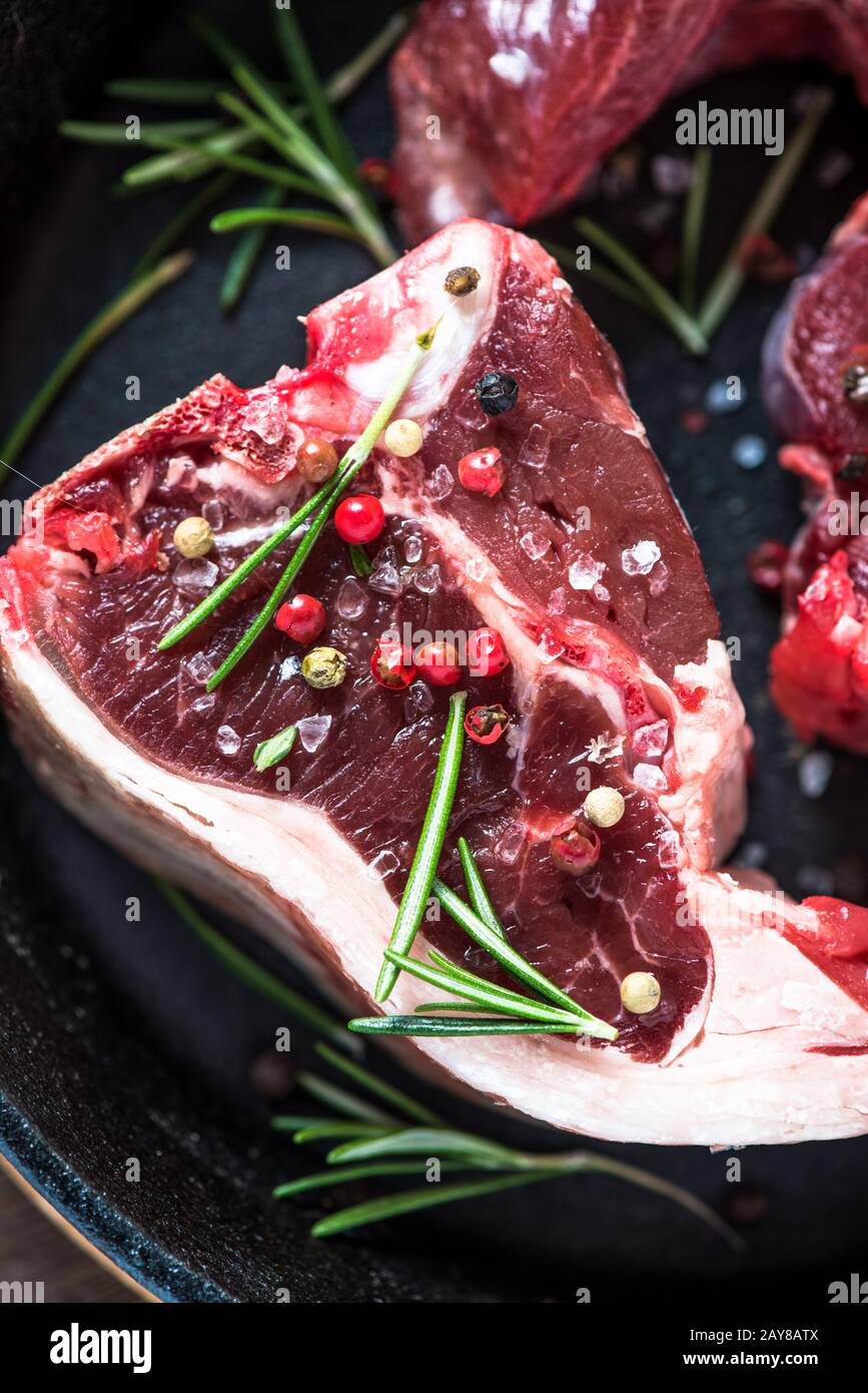 Raw lamb chops with fresh rosemary herb Stock Photo