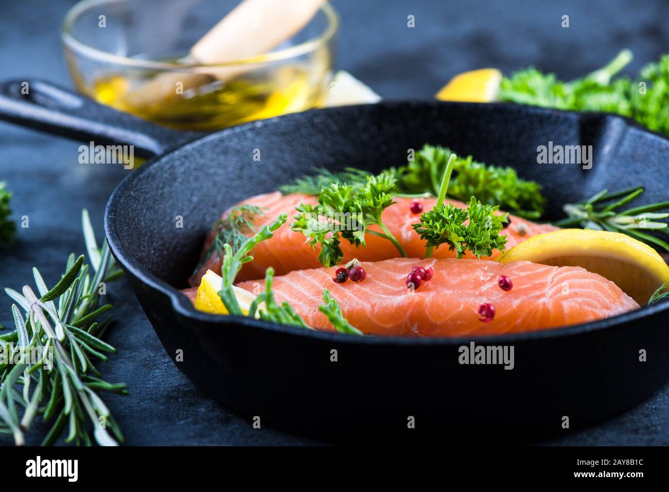 salmon steaks with herbs on rustic pan Stock Photo