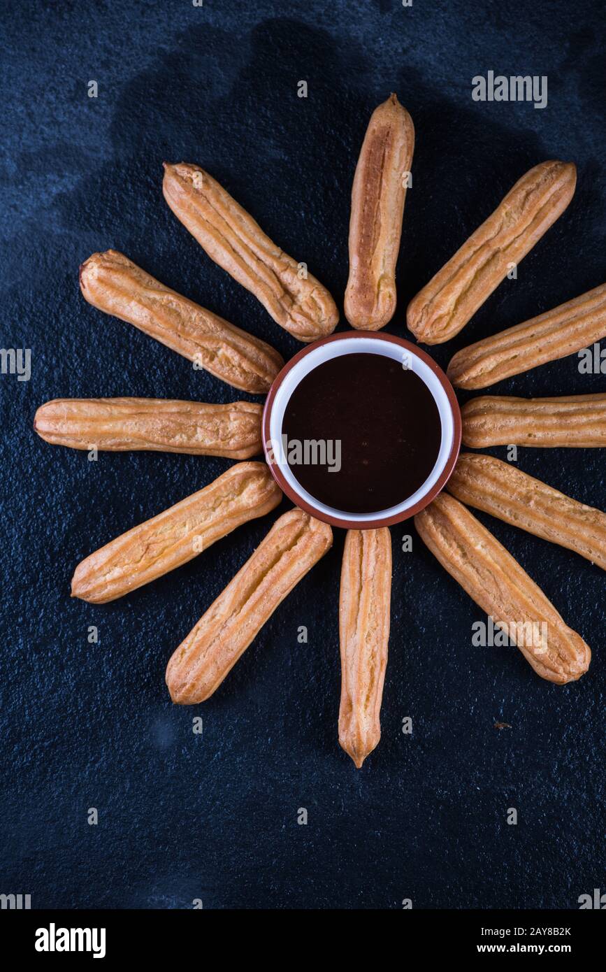 Fried churros with chocolate dip, mexican sun Stock Photo