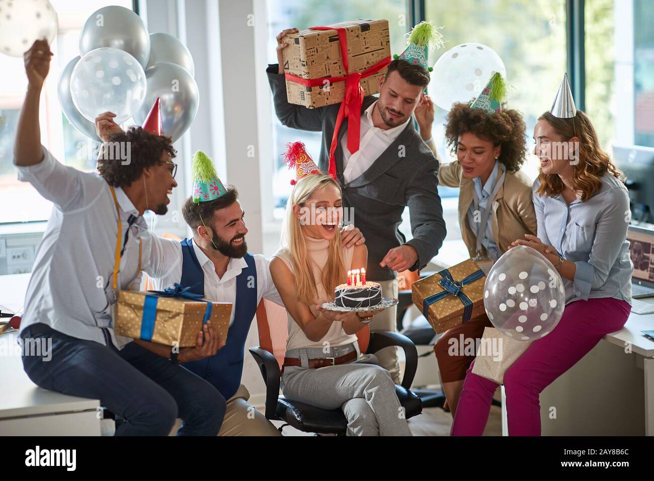 colleagues celebrating birthday at work in office. birthday party at