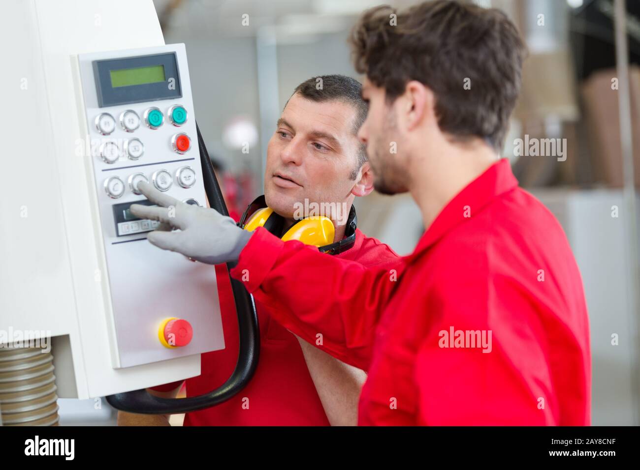 workers operating cnc metal skip in factory Stock Photo