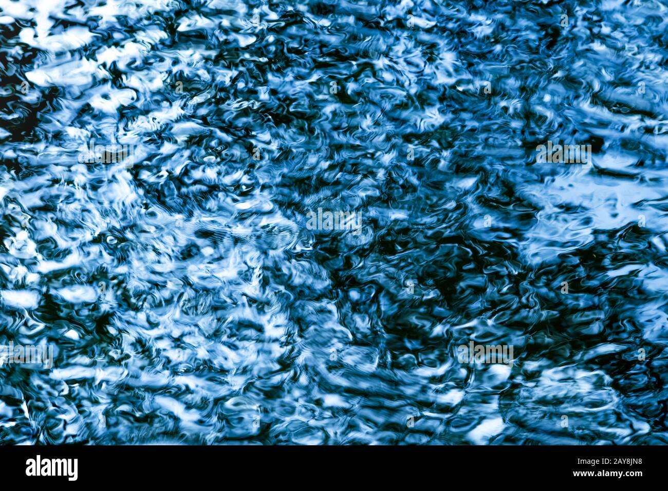 Abstract sparkling blue water surface with small waves as texture / background Stock Photo