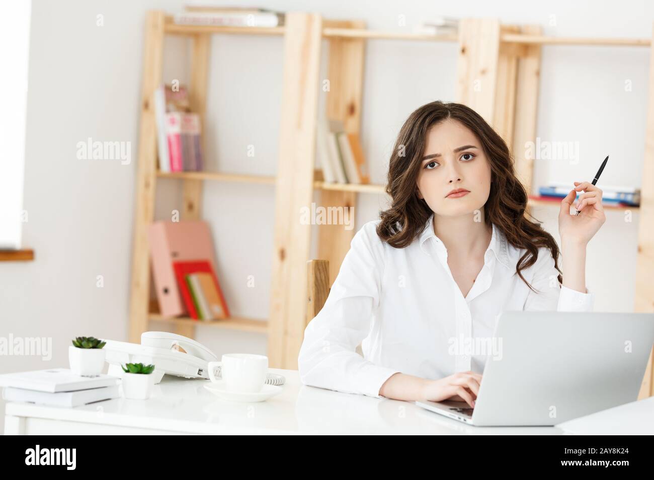 Young attractive woman at a modern office desk, working with laptop ...