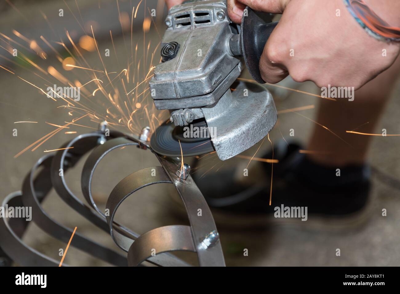 Flying sparks during metalworking with an angle grinder - close-up Stock Photo