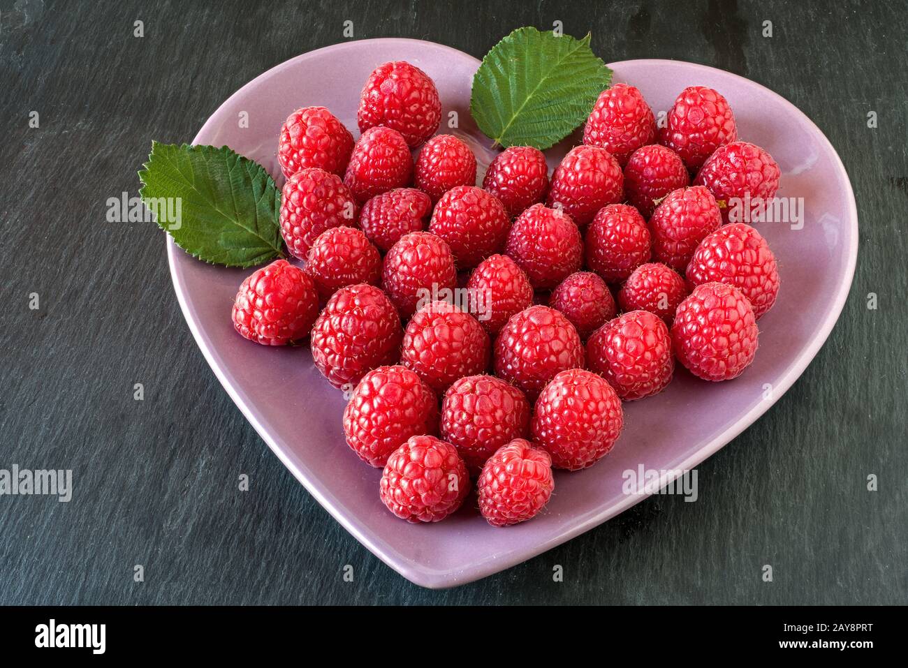 Raspberries in a heartshaped bowl Stock Photo Alamy