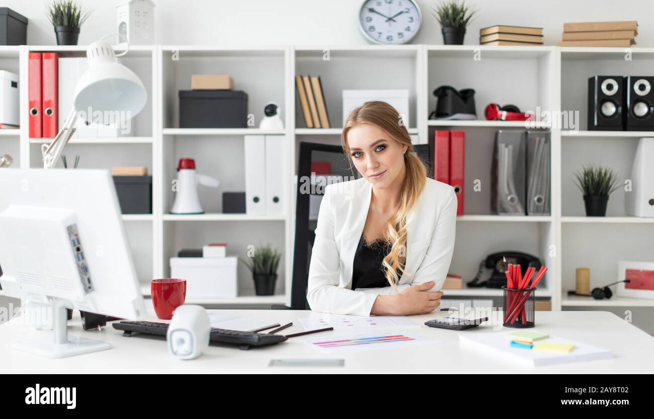 A young girl is sitting at the computer desk in the office Stock Photo ...