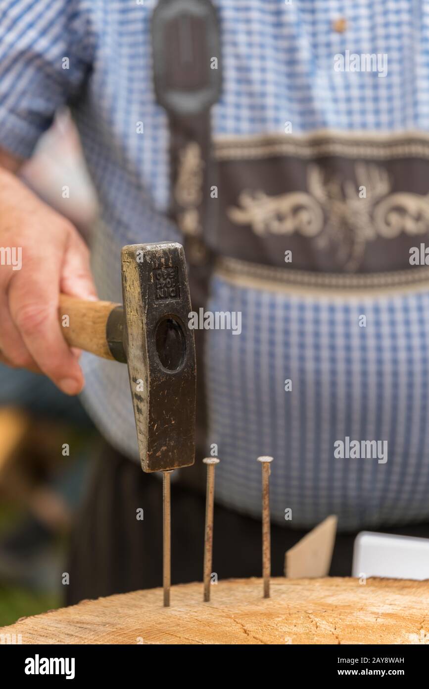 Man in traditional costume with hammer Stock Photo