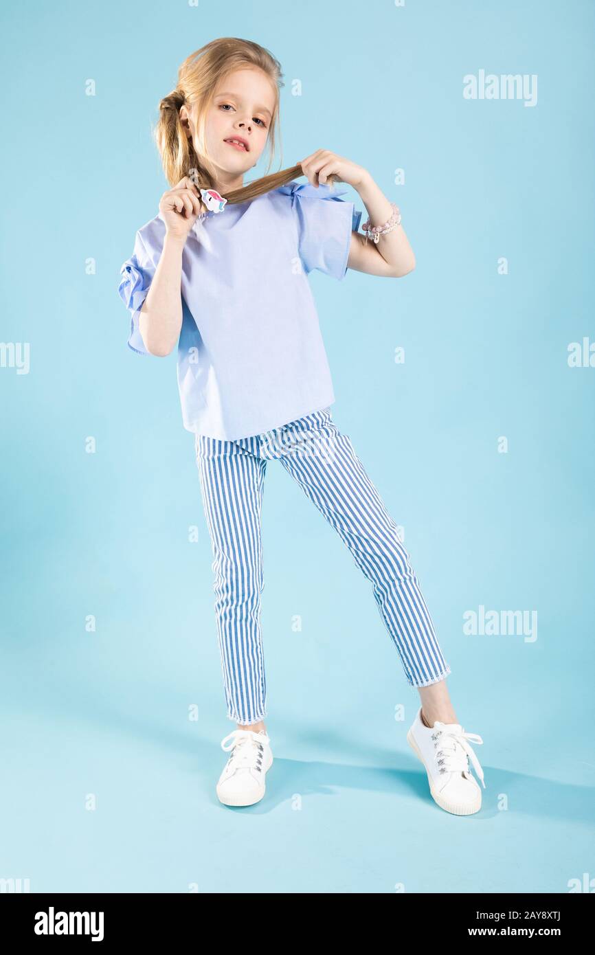 Full-length portrait of a beautiful girl in blue clothes on a blue background. Stock Photo
