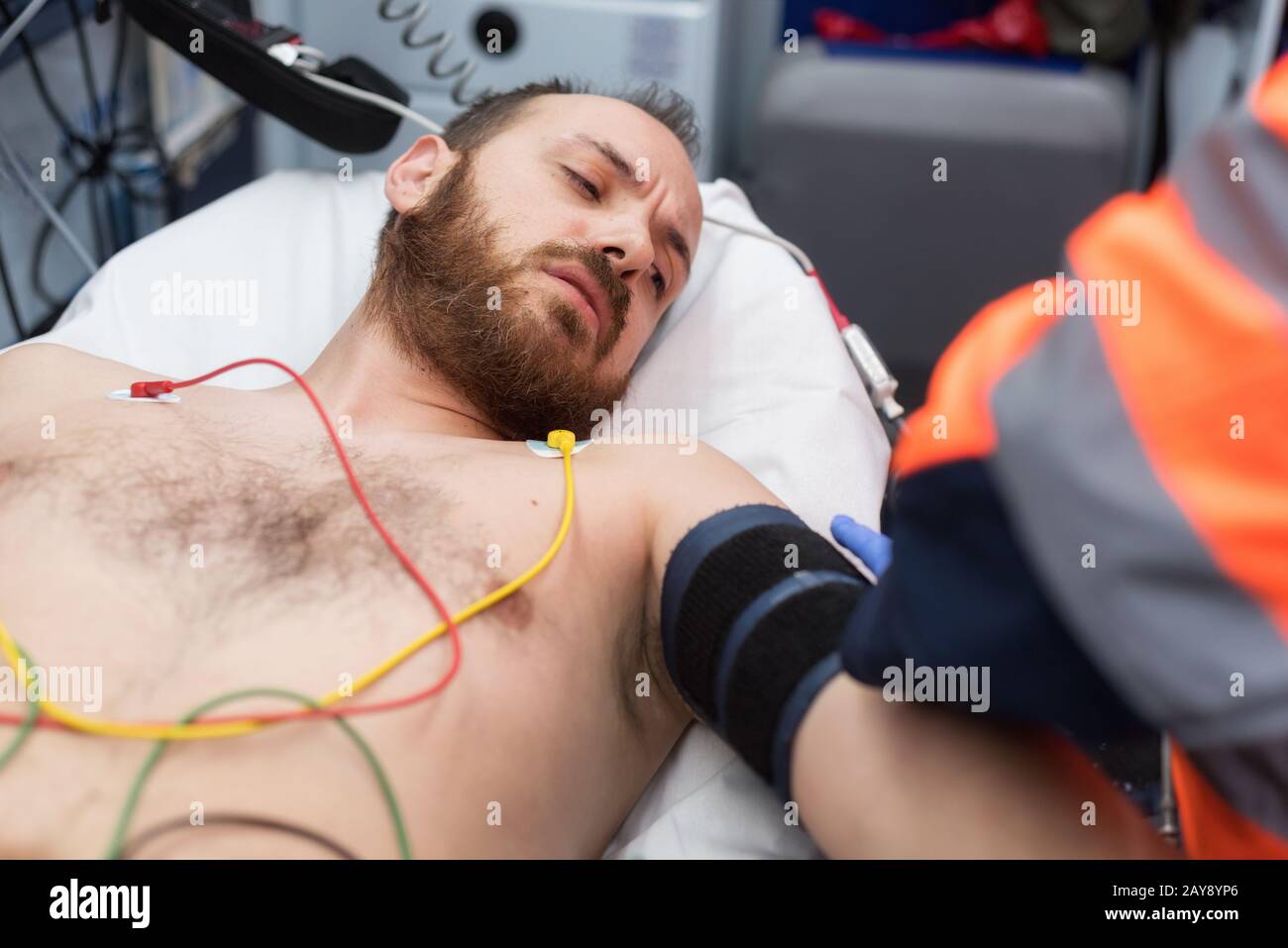Emergency doctor checking blood pressure of a patient in the ambulance Stock Photo