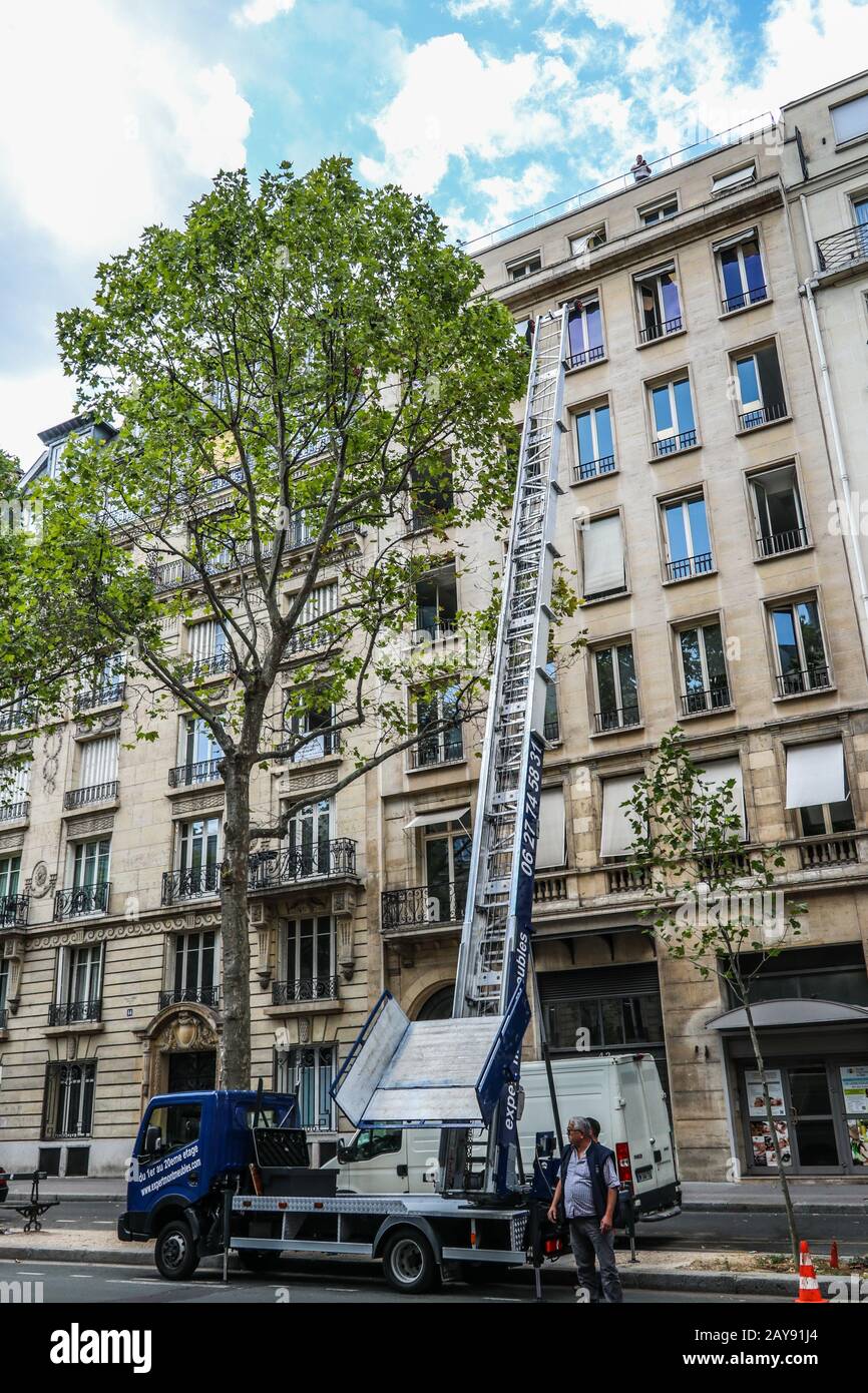 Truck with tall extended ladder by apartment building in Paris, France Europe Stock Photo