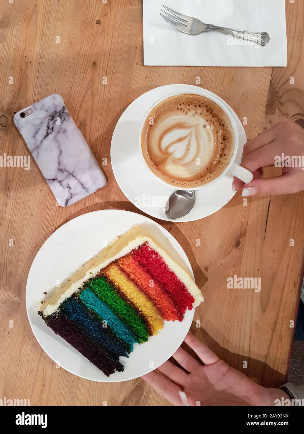 Female hand holding coffee cup and cake plate Stock Photo