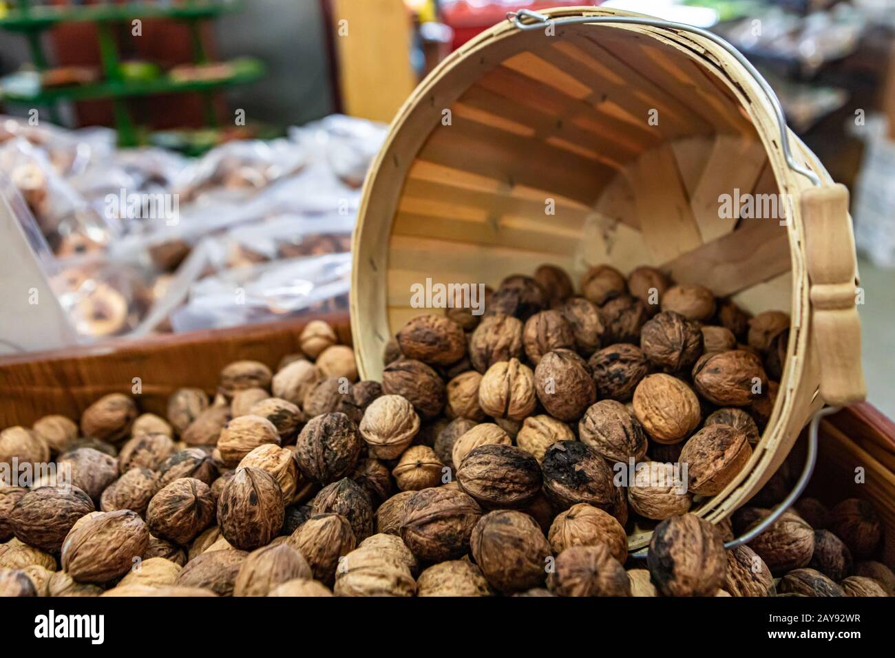 Dried fruit on sale at the local food market. Walnuts coming out of a round wooden basket. Natural snack or ingredient, healthy eating. Superfood. Stock Photo