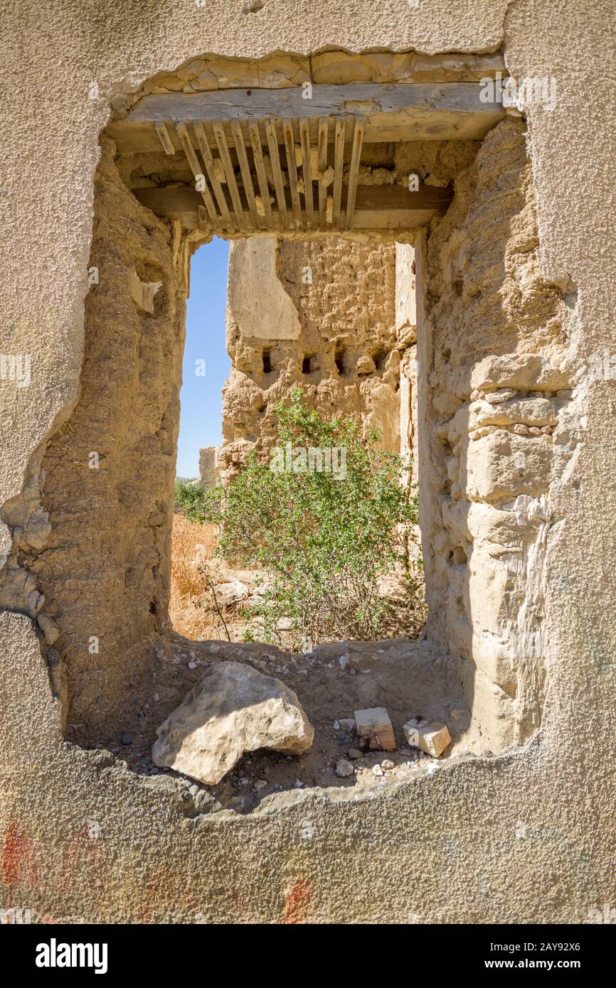 View through destroyed window of ruins of the  abandoned village of Agios (Saint) Sozomenos, Cyprus Stock Photo