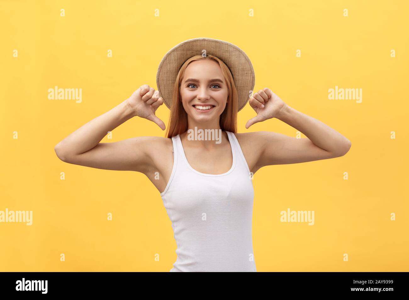 Clothing, design and advertising concept. Indoor shot of positive friendly young female pointing at copy space on her blank whit Stock Photo