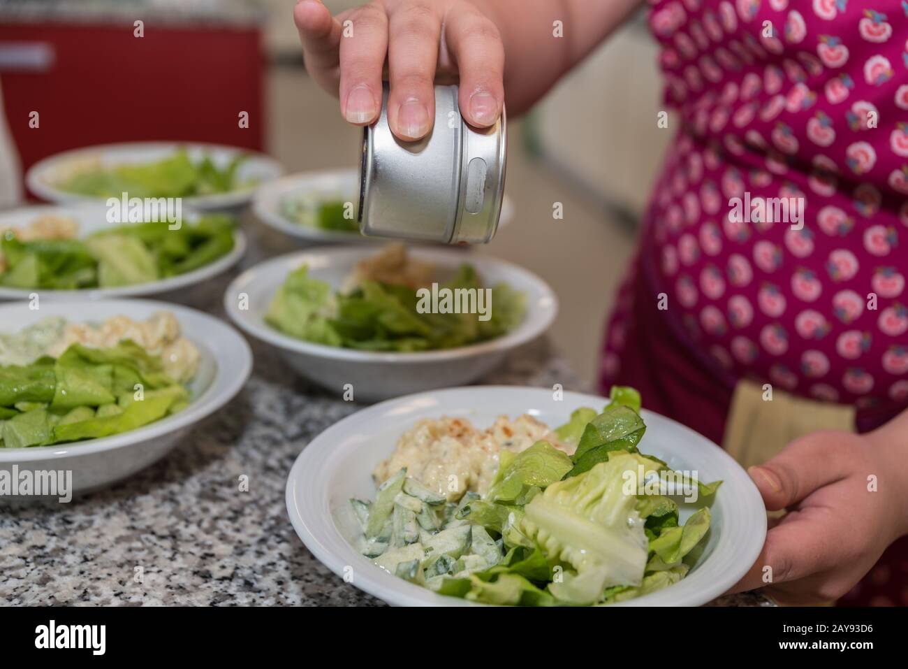 prepare different salads and season them in the plate - close-up Stock Photo