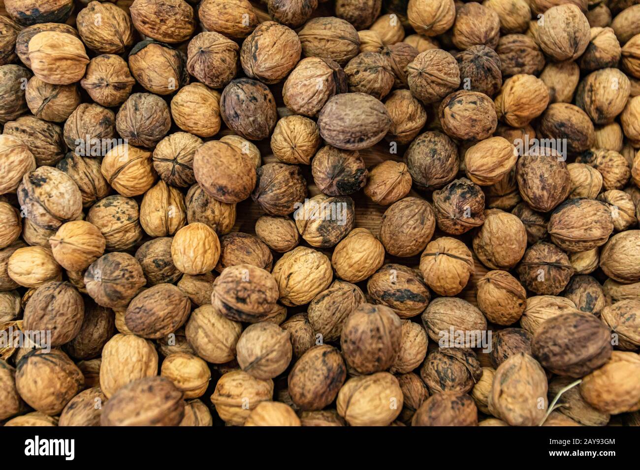 Natural food patterns and geometries. Full frame close up of fresh, dried walnuts full of nutrients. Selective focus. Wallpaper or background use. Stock Photo