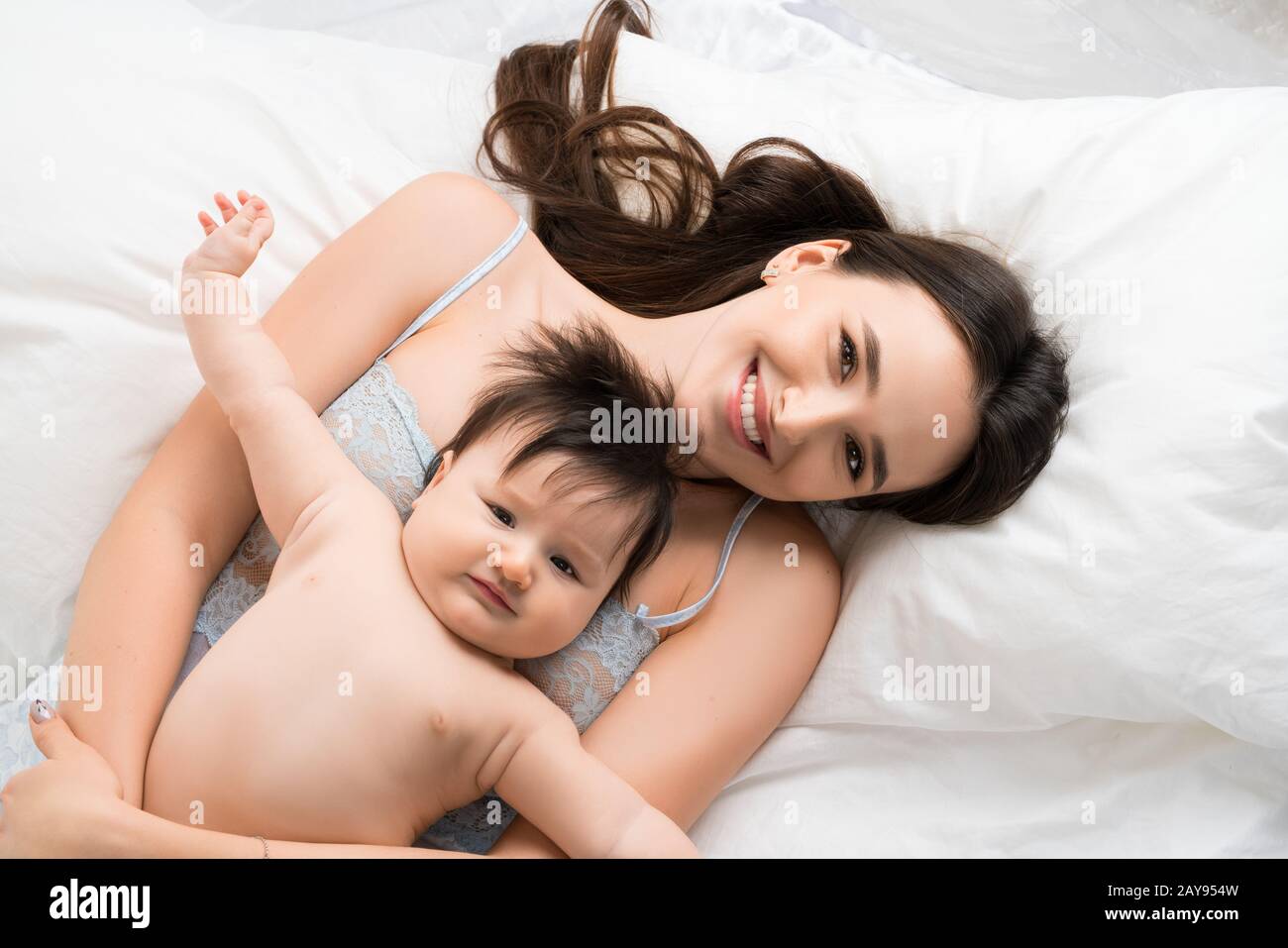 Happy mother in bed with baby boy high angle shot Stock Photo