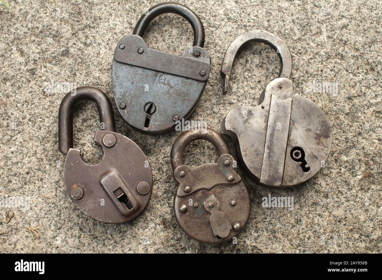 Old weathered grunge retro open and locked padlocks closeup on solid stone surface background Stock Photo