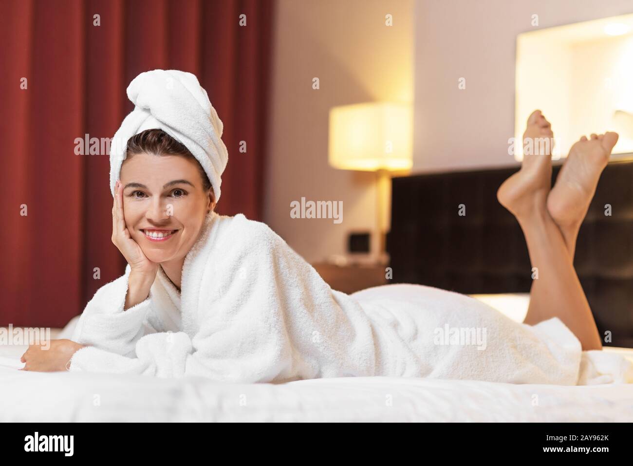 Young woman in bathrobe lying in hotel room, relaxed after taking a bath Stock Photo Alamy