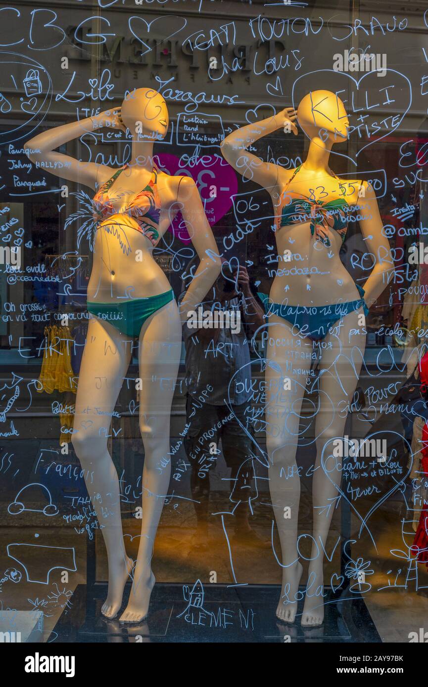 Mannequins behind a labeled glass pane. Stock Photo