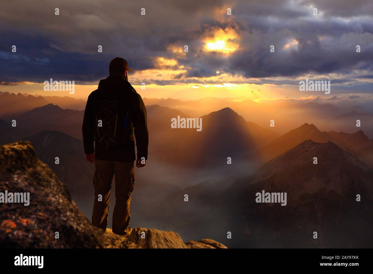 Young male hiker standing on the peak of the mountain Stock Photo - Alamy