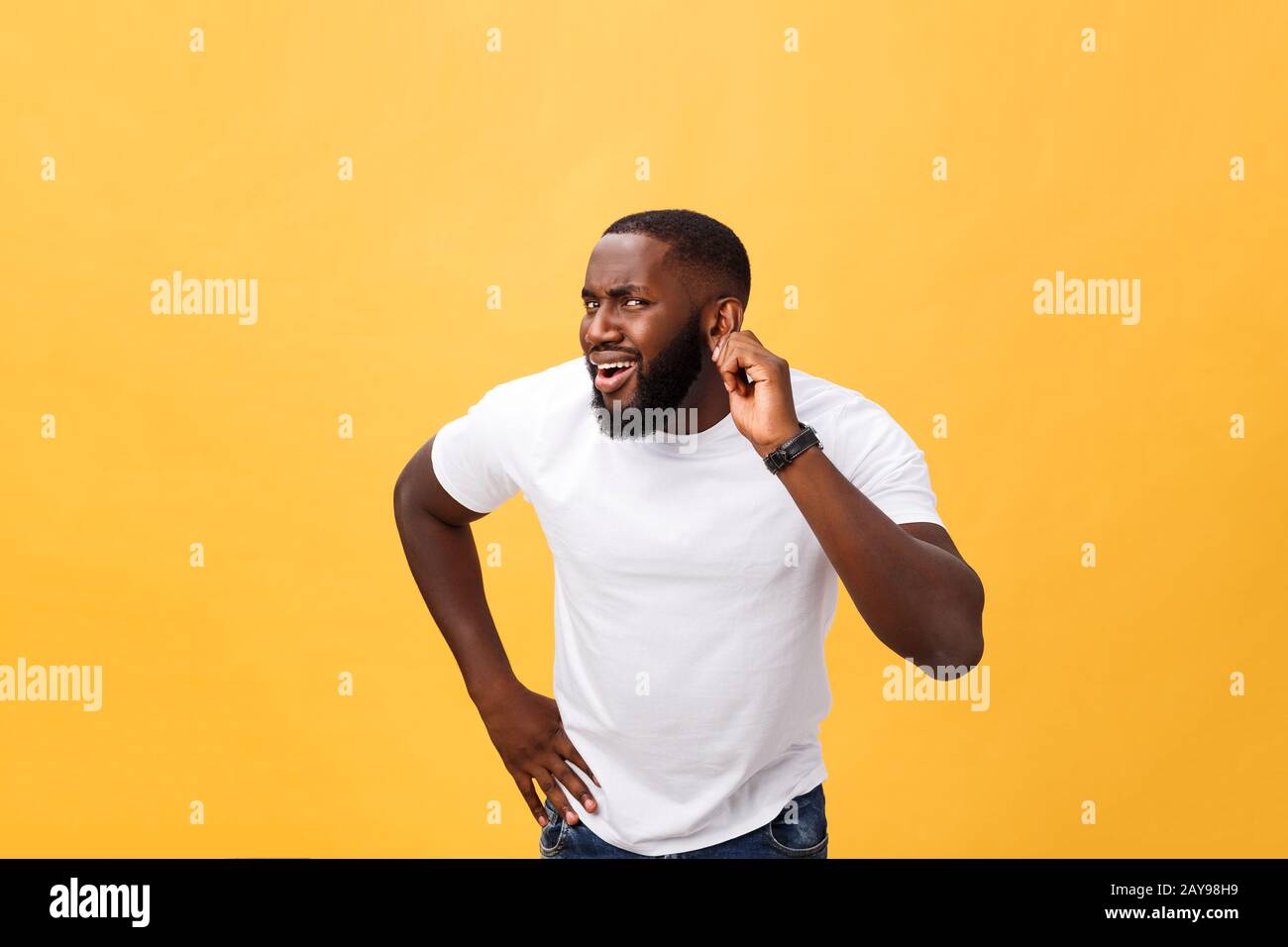 Headshot of goofy surprised bug-eyed young dark-skinned man student wearing casual white t-shirt staring at camera with shocked Stock Photo