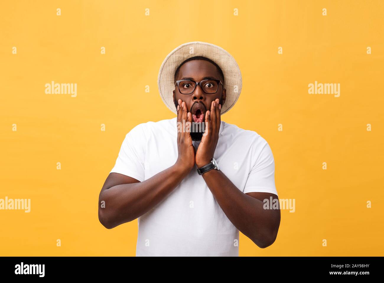 Headshot of goofy surprised bug-eyed young dark-skinned man student wearing casual white t-shirt staring at camera with shocked Stock Photo