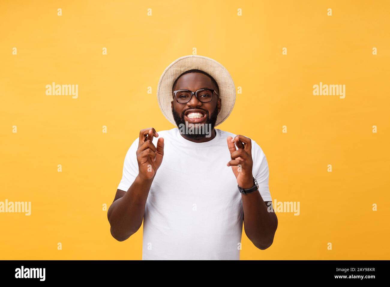 Young african american man over isolated background smiling crossing fingers with hope and eyes closed. Luck and superstitious c Stock Photo