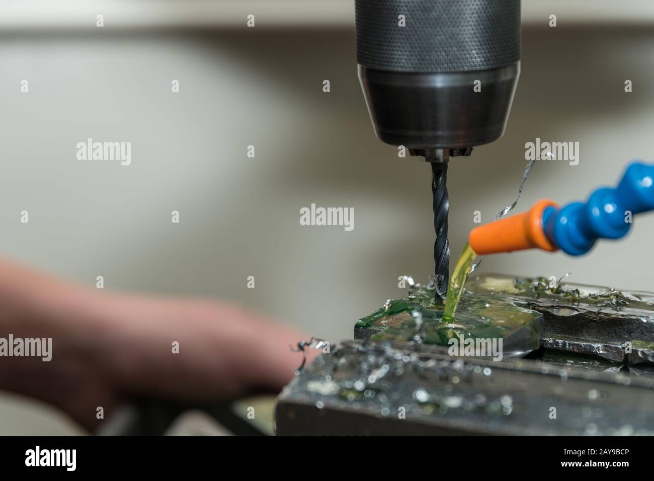 Drill holes in plastic using a drill and a coolant in coolant - close-up Stock Photo