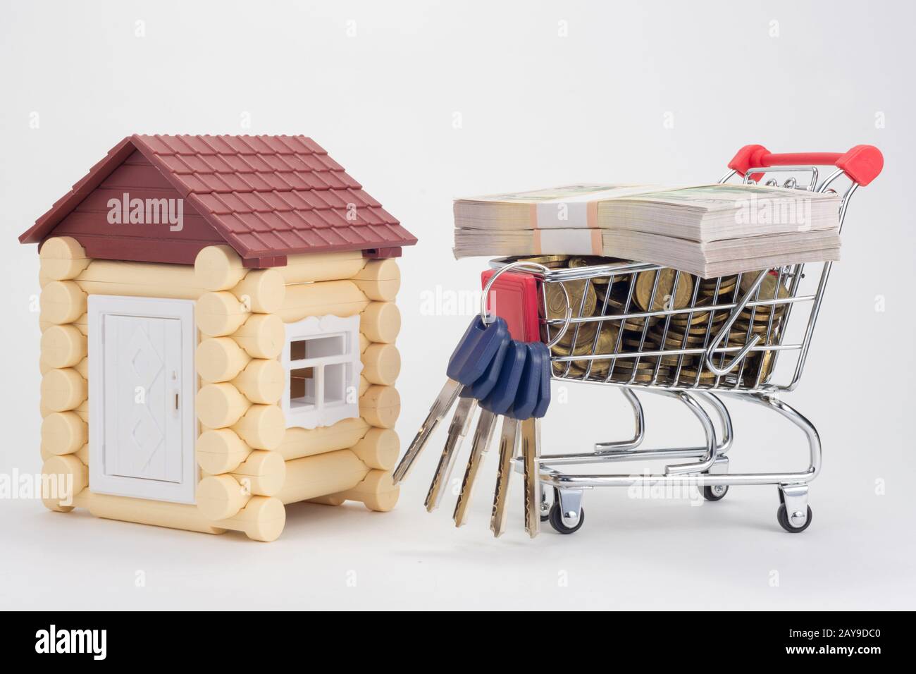 Toy house, trolley with money and a bunch of house keys Stock Photo