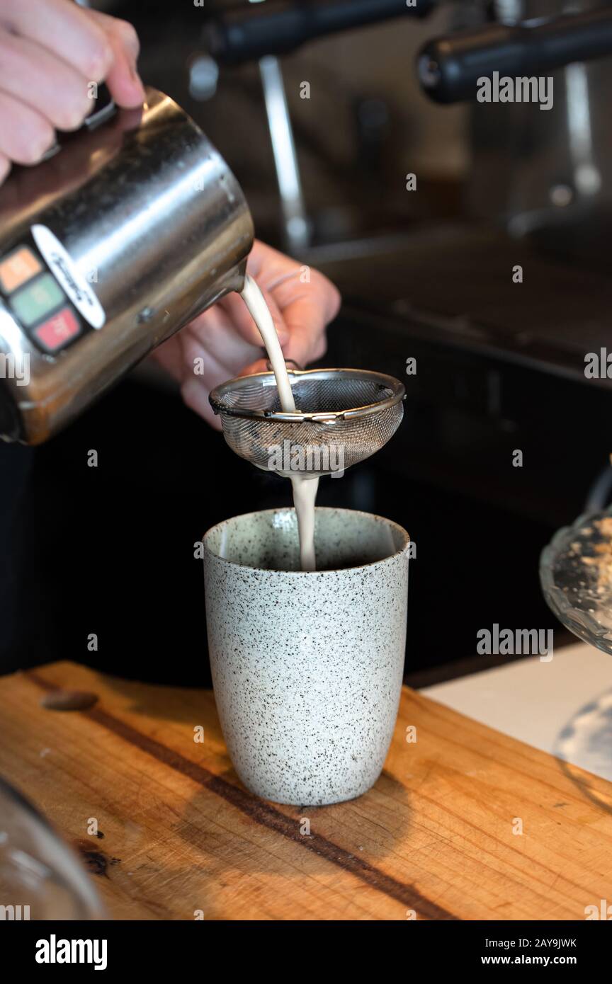 barista pouring milk for chai latte Stock Photo Alamy