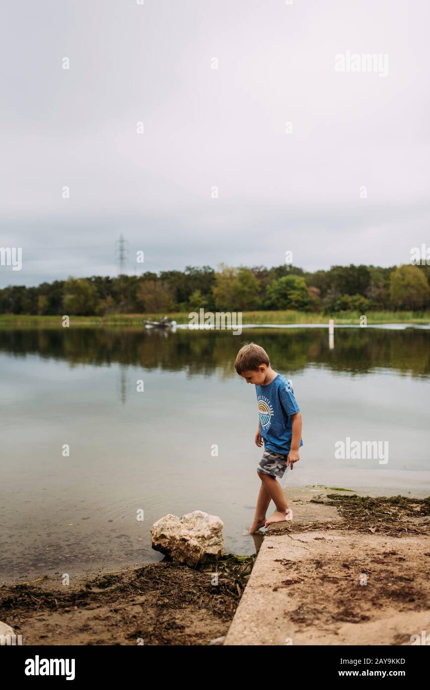 Young Boy Dipping Toes in the Water at Lake Bastrop Stock Photo