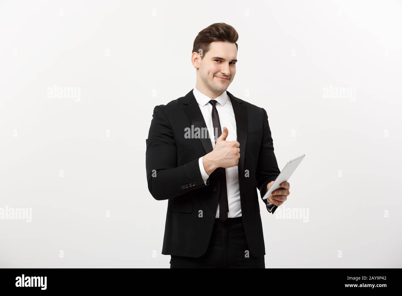 business, communication, modern technology and office concept - smiling buisnessman with tablet computer showing thumbs up. Isol Stock Photo