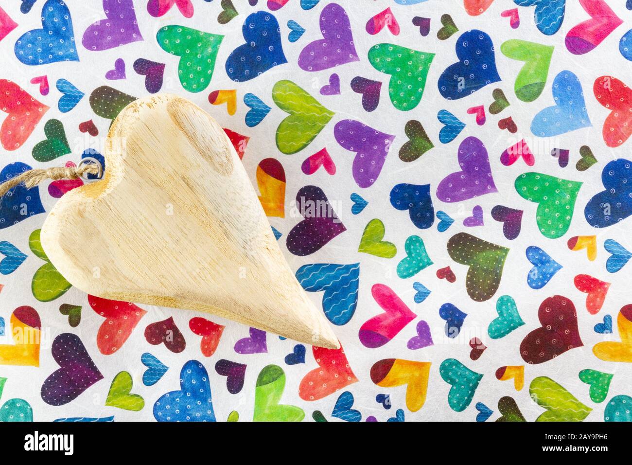 Wooden heart on paper containing hearts for Valentines Day Stock Photo